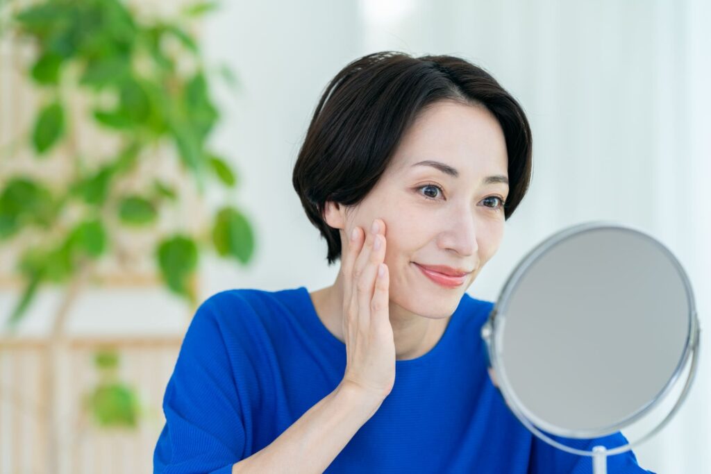 鏡を見ながら笑顔の女性のイラスト