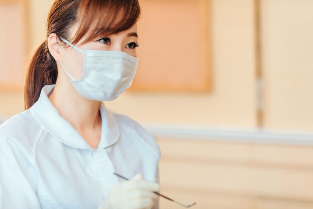 歯科衛生士が歯科検診で使用する器具を持っている様子