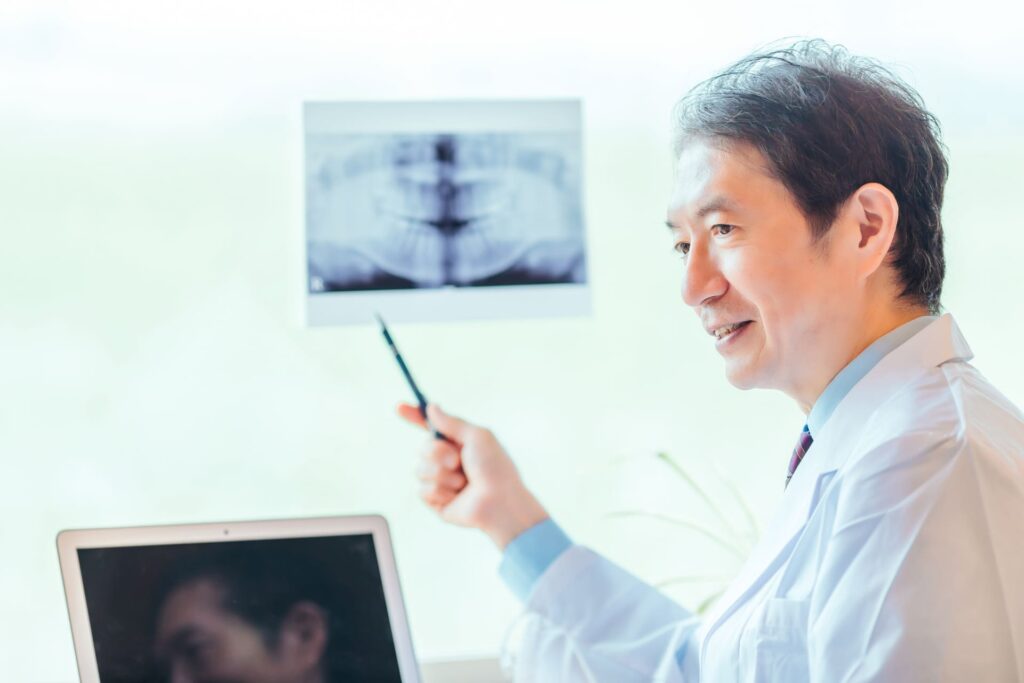 歯科医師が患者に口腔内の状態について説明している様子