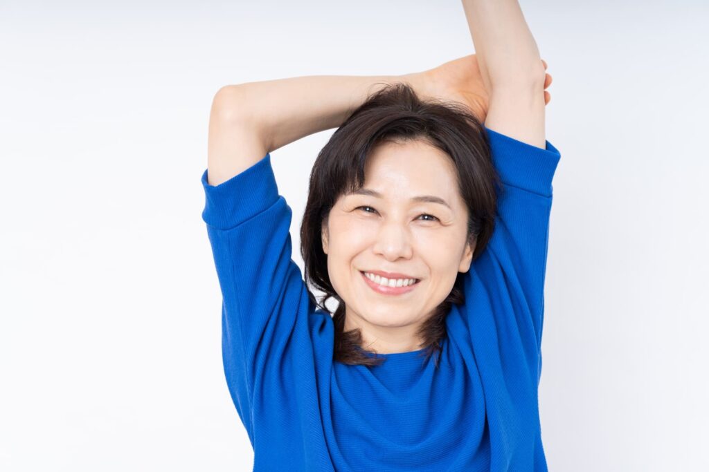 白い歯で自然な笑顔を見せる女性のイメージ写真