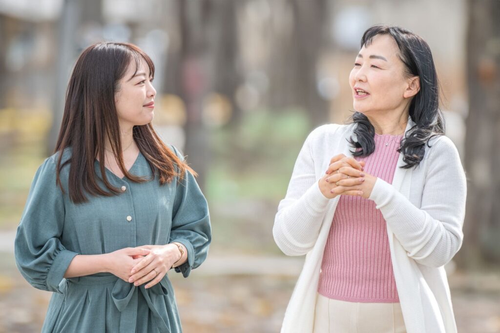 会話をしながら自然に笑顔を見せる女性二人のイメージ写真