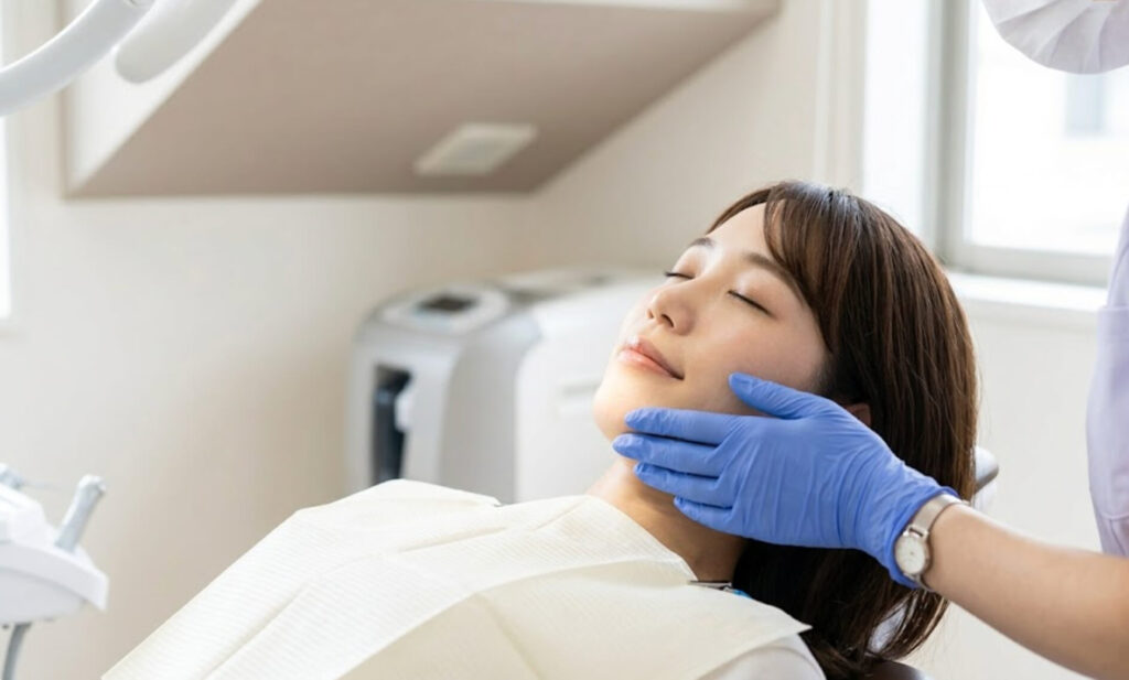 歯科スタッフの優しい手添えに安心し、穏やかな表情を見せる日本人女性の様子