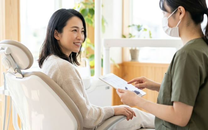 タブレットを使った説明に耳を傾ける日本人女性