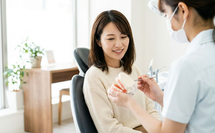 定期検診で歯科衛生士と相談する日本人女性