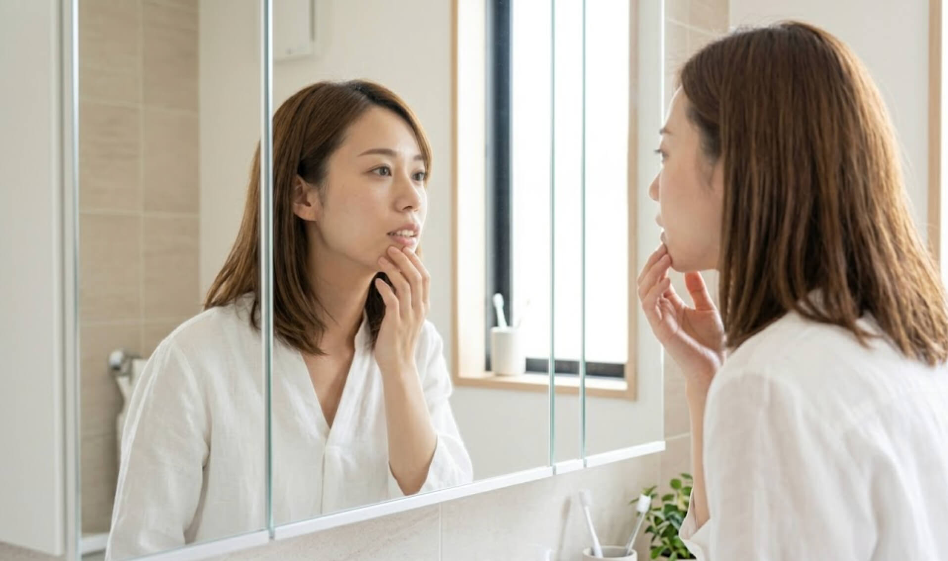 洗面所の鏡で自分の横顔と出っ歯の状態を客観的にチェックする日本人女性の様子