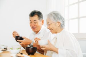 高齢の夫婦が自宅で食事を楽しんでいる様子