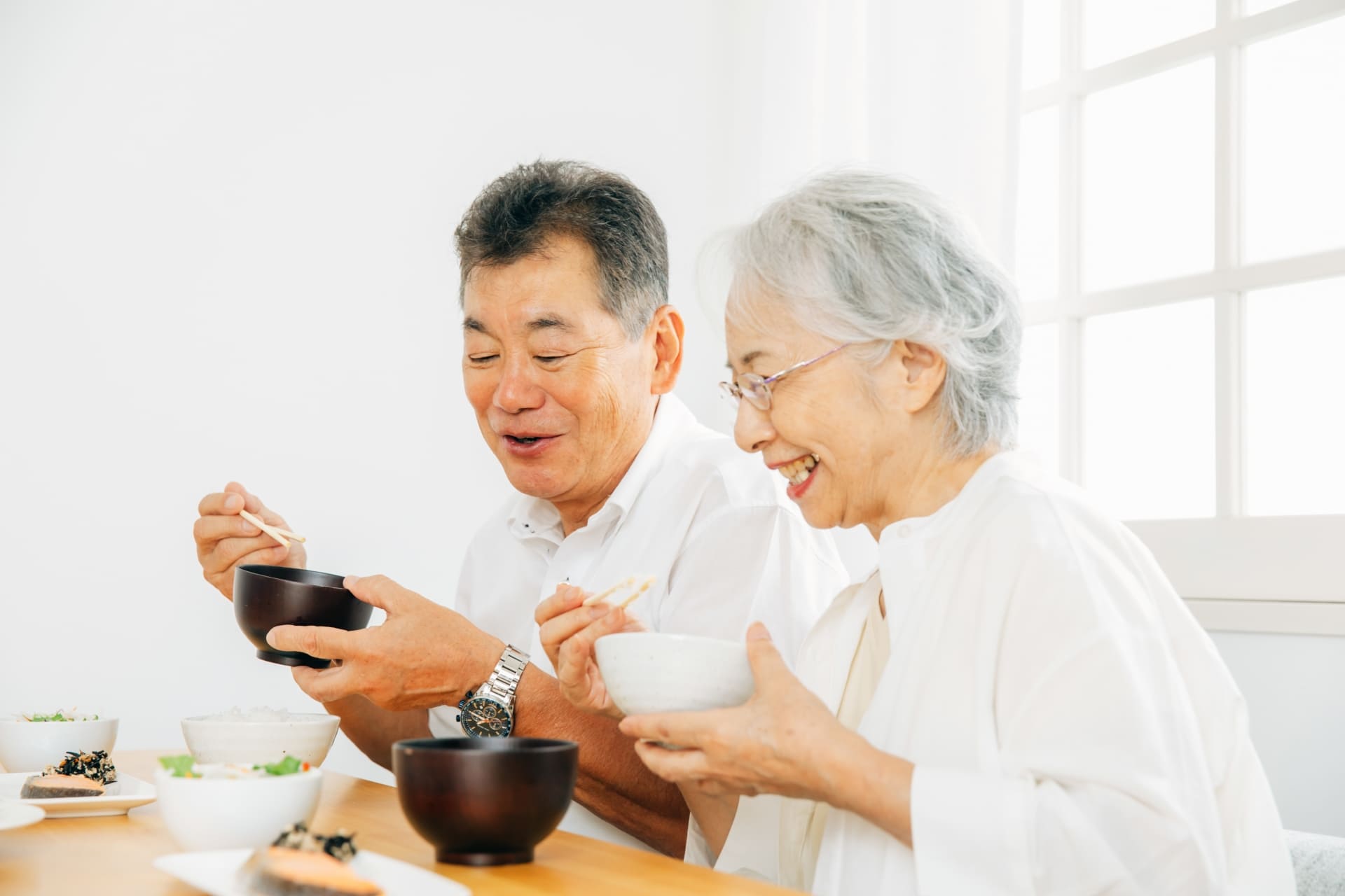 高齢の夫婦が自宅で食事を楽しんでいる様子