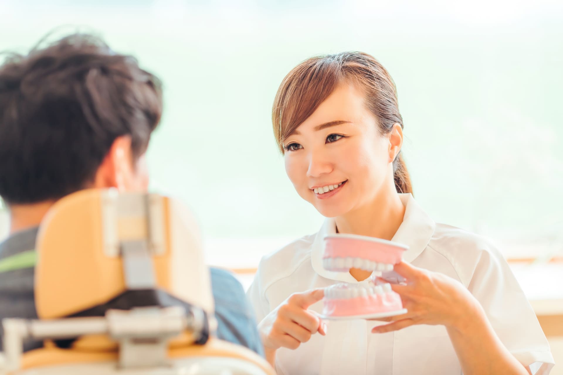 歯科医院で歯科衛生士が患者と落ち着いて会話している様子