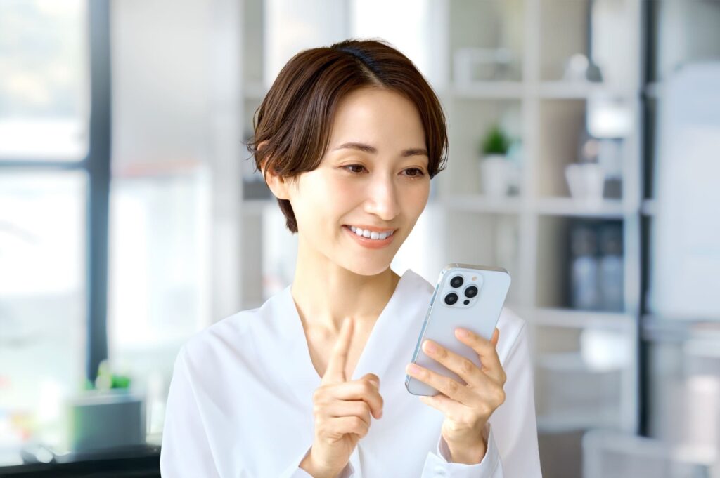 携帯電話で歯医者に関する情報を調べている女性の様子