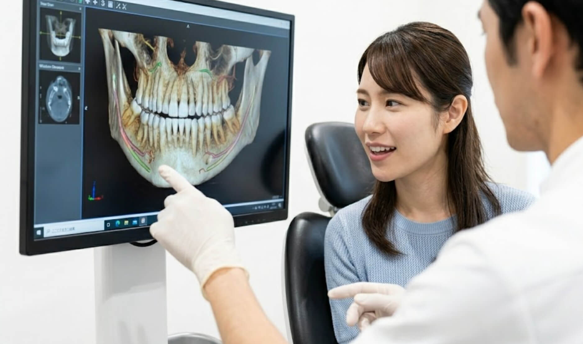 歯科用CTの3D画像と親知らずの位置関係について説明を受ける患者の日本人女性