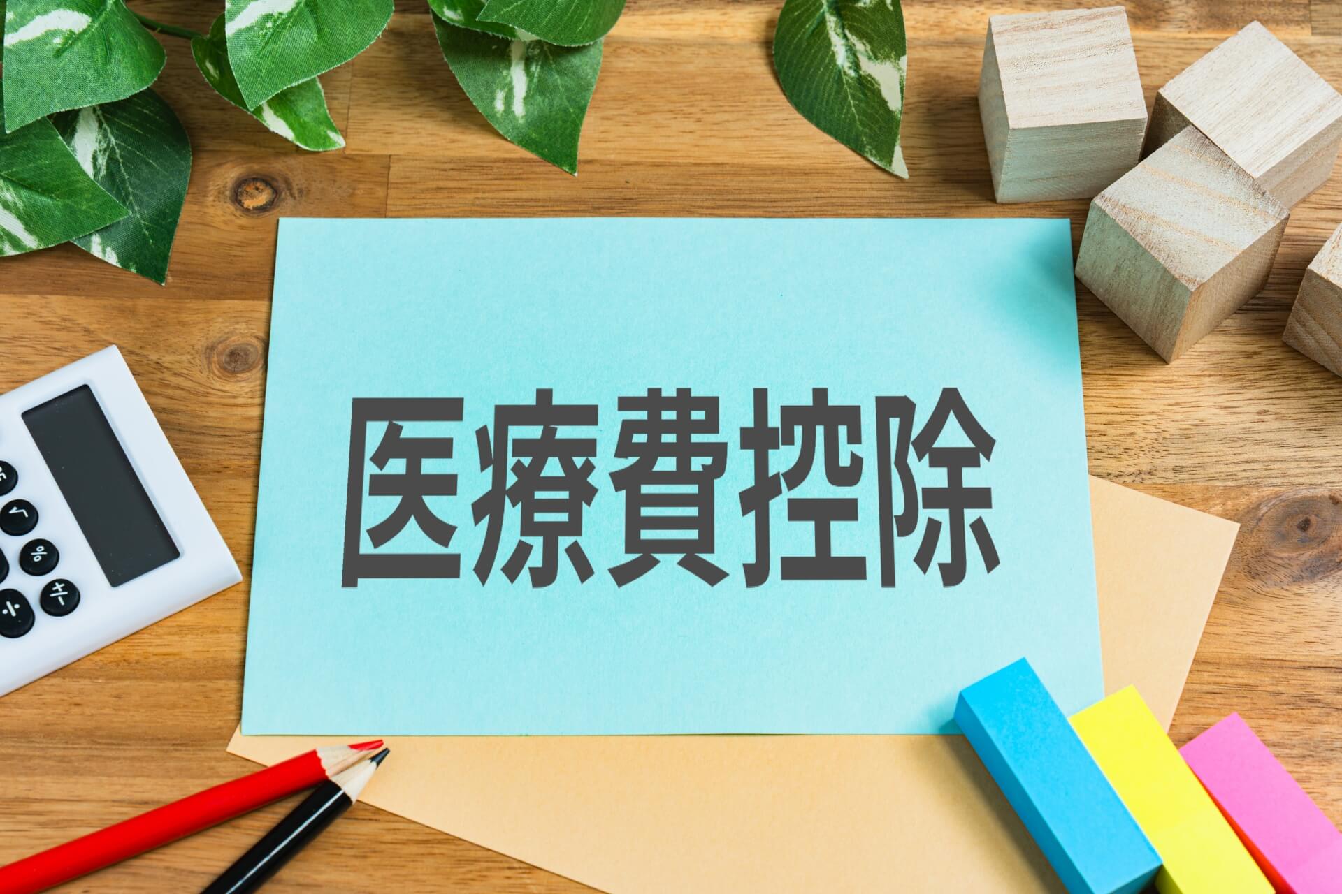インプラントの費用負担を抑える制度をイメージした、電卓や文房具が並ぶ机の上の様子
