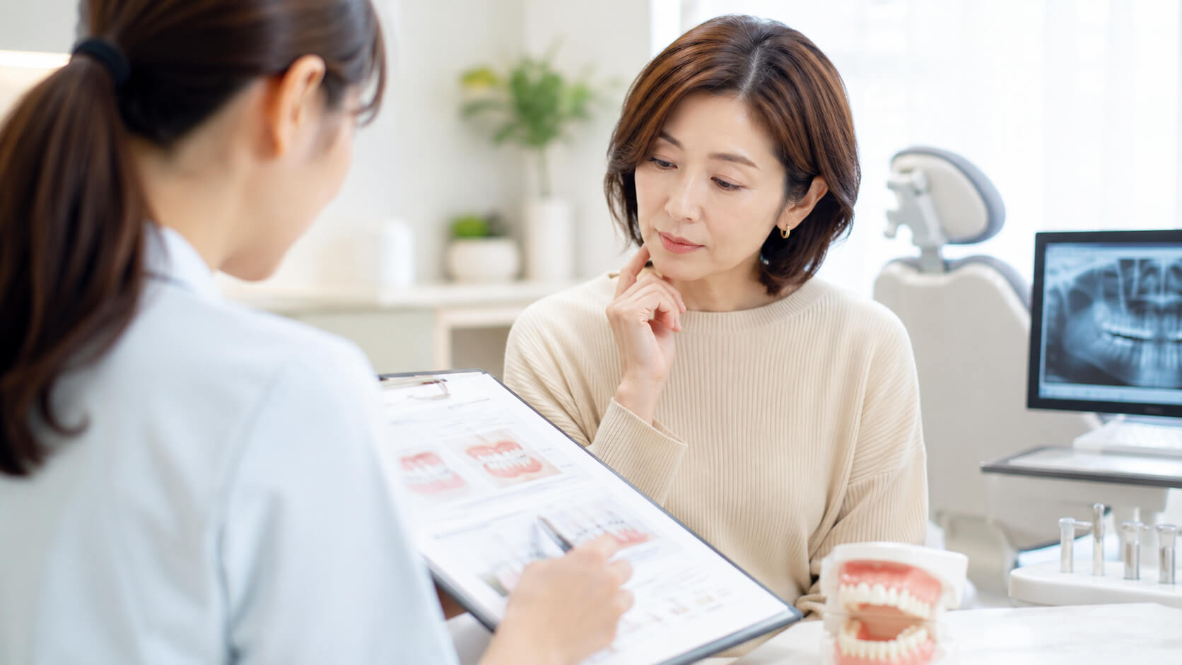 矯正治療の保険適用について歯科医院で相談する女性の様子