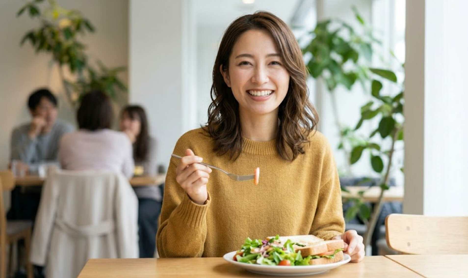 カフェで健康的な食事を前に、満足げに微笑む別の日本人女性の自然な笑顔の様子
