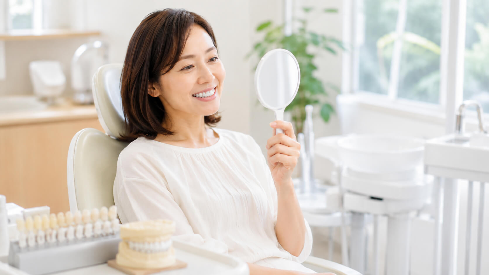 鏡で自然な白い歯を確認する日本人女性の様子