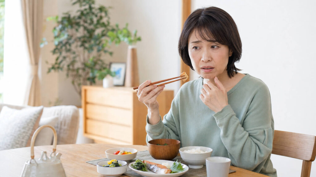 歯の痛みで食事がしにくい日本人女性の様子